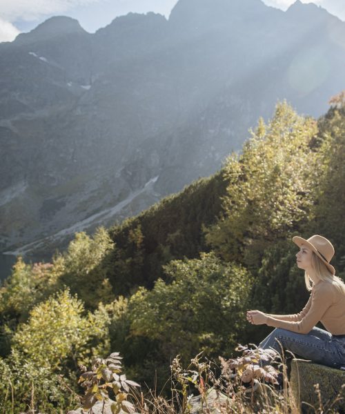 Young woman on a hiking trip sitting on a rock Young woman on a hiking trip sitting on a rock